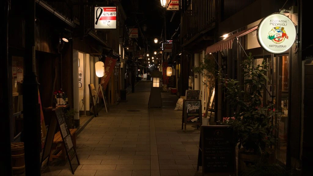 A quiet Kyoto side street at dawn, machiya townhouses lit by a single warm streetlamp